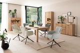 Moderne Esszimmer-Einrichtung mit Holztisch, gepolsterten Drehstühlen und Vitrinen in einem hellen Raum mit großen Fenstern, seitliche Perspektive.