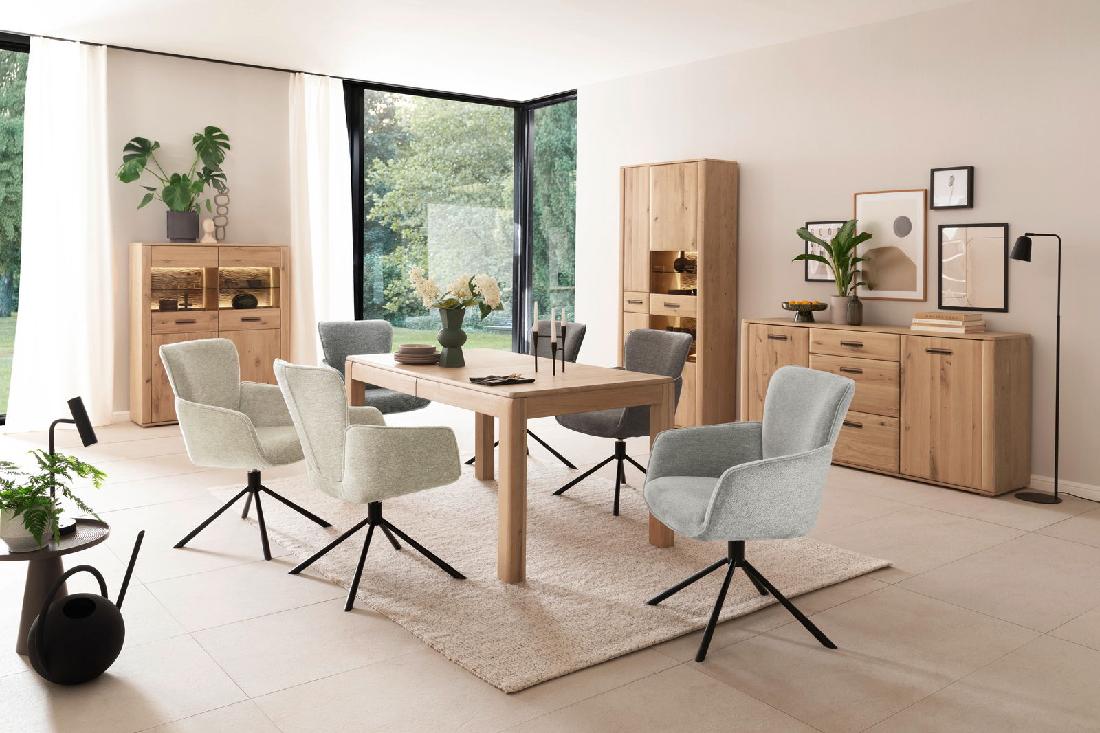 Moderne Esszimmer-Einrichtung mit Holztisch, gepolsterten Drehstühlen und Vitrinen in einem hellen Raum mit großen Fenstern, seitliche Perspektive.