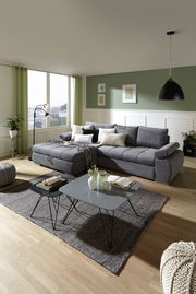 Graue Rundecke mit Ottomane links in modernem Wohnzimmer, seitliche Perspektive