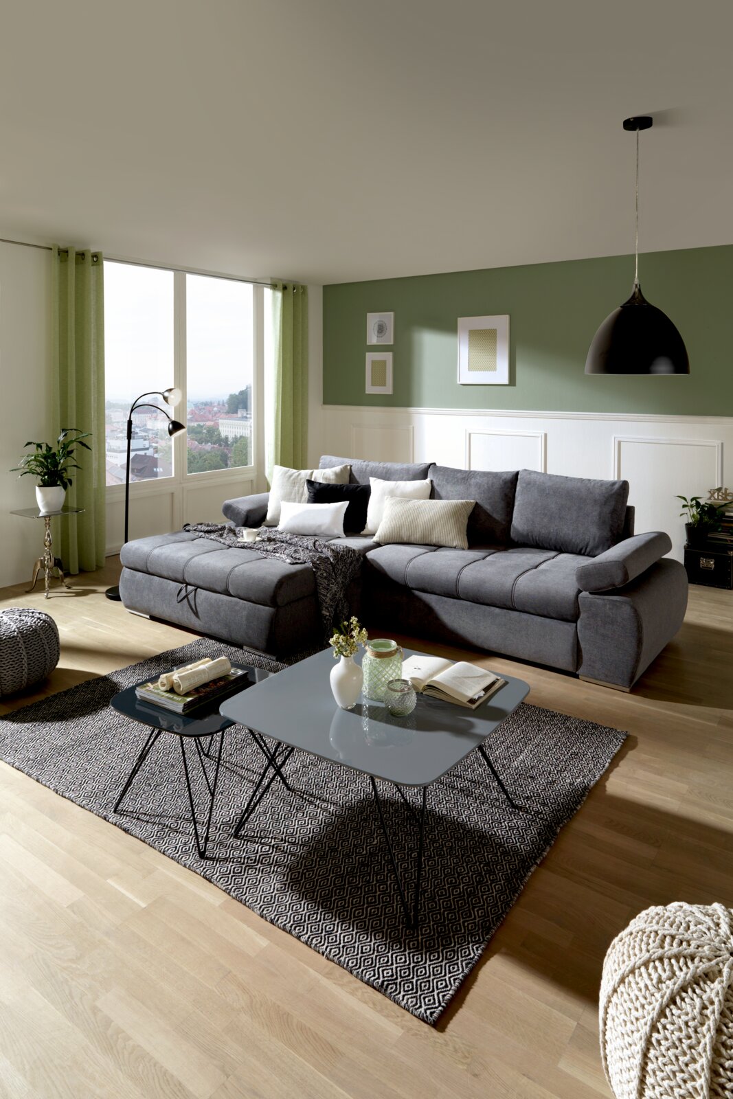 Grijze hoekbank met poef links in een moderne woonkamer, zijaanzicht