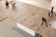 Moderner Esstisch aus Holz in Nahaufnahme, von oben fotografiert, mit Dekorationen wie einer Vase, Schalen und Besteck.