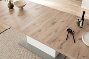 Moderner Esstisch aus Holz in Nahaufnahme, von oben fotografiert, mit Dekorationen wie einer Vase, Schalen und Besteck.