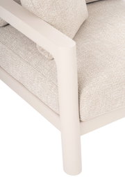 Close-up van een loungestoel met een beige stoffen bekleding en een crèmekleurig metalen frame, gezien vanaf de zijkant.