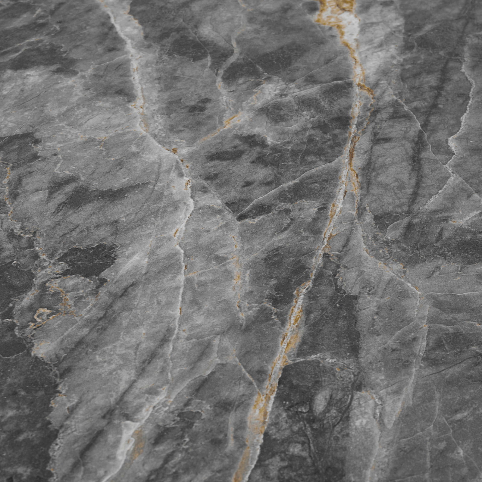 Nahaufnahme einer Tischplatte aus grauem Marmor mit goldenen Adern, von oben betrachtet.