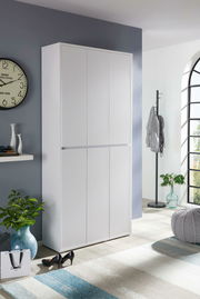 Weißer Schuhschrank in einem modernen Raum, frontal fotografiert, mit dekorativen Elementen wie einer Uhr und Pflanzen.