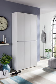 Weißer Schuhschrank in einem modernen Raum, frontal fotografiert, mit dekorativen Elementen wie einer Uhr und Pflanzen.