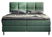 Grünes Boxbett mit gestepptem Kopfteil, frontal fotografiert, mit grauer Bettwäsche und Kissen.