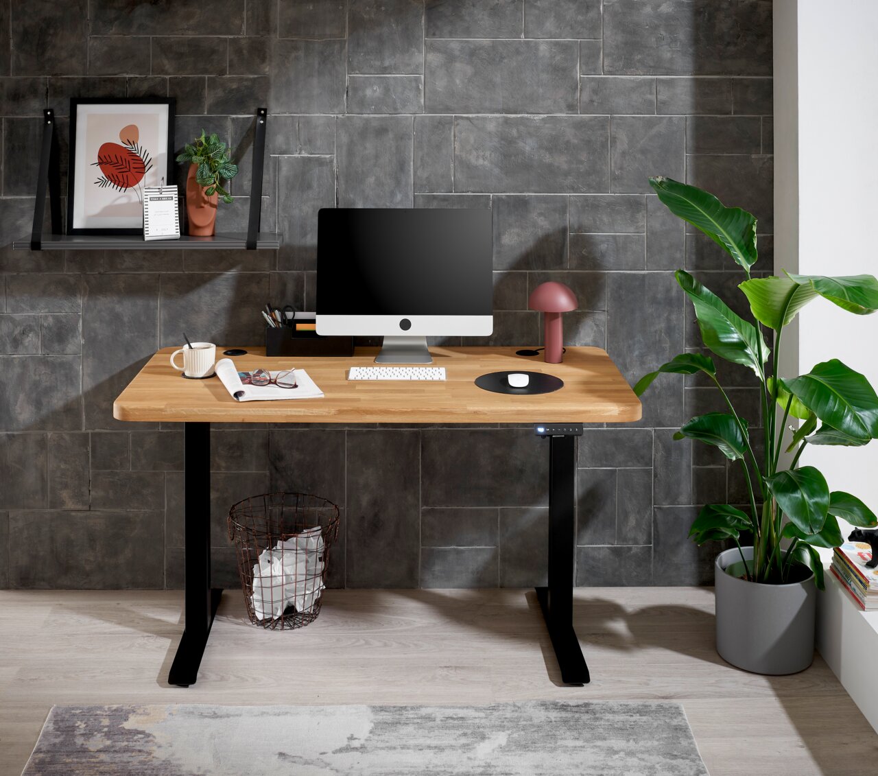 Moderner E-Schreibtisch mit Holzplatte und schwarzem Gestell, frontal fotografiert, ausgestattet mit Computer, Lampe und Dekoration.