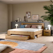 Modernes Holzbett in Eiche-Optik mit gepolstertem Kopfteil, integrierten Schubladen und passendem Nachttisch im Schlafzimmer, Frontansicht in leichter Schrägperspektive von links