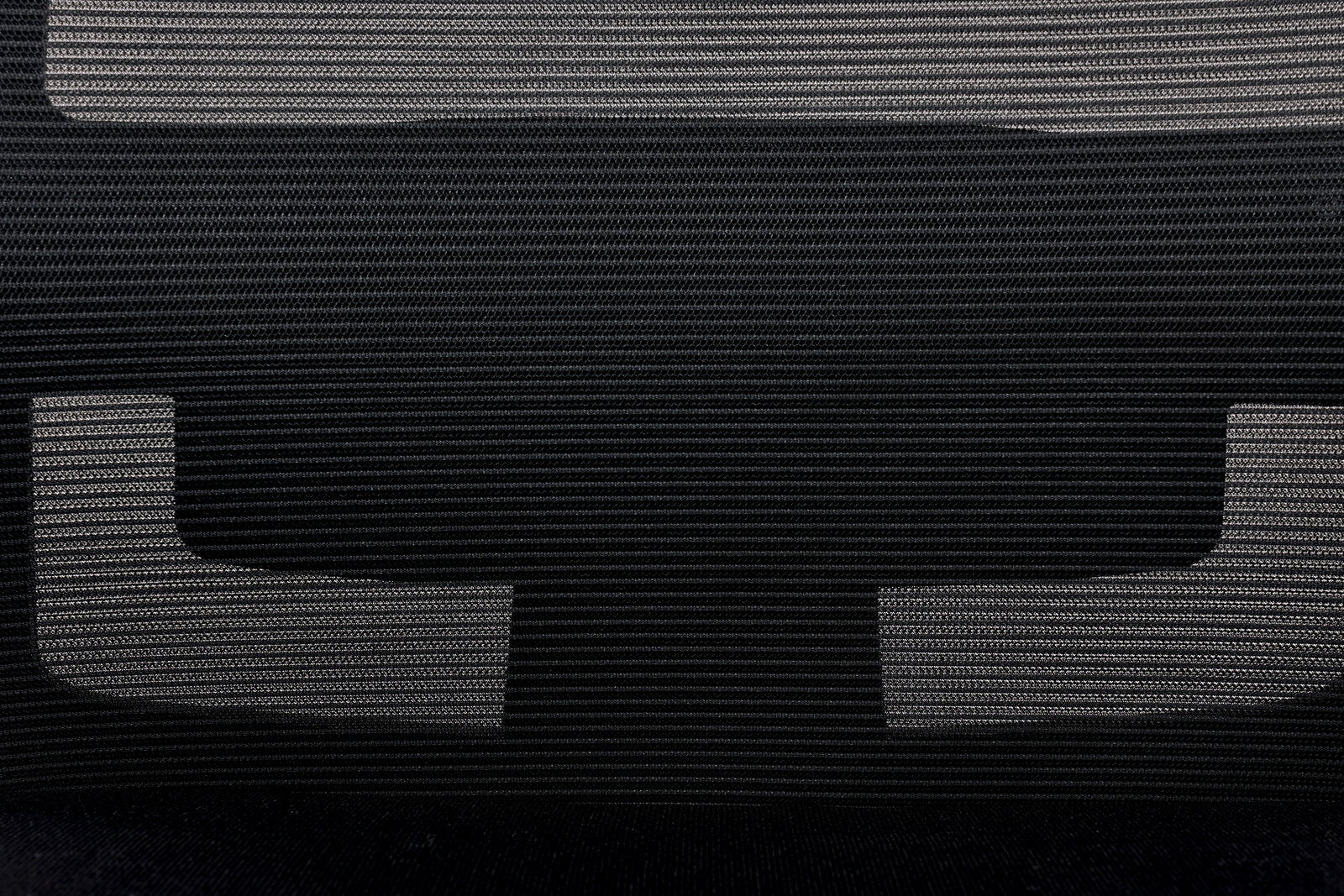 Nahaufnahme der Rückenlehne eines Besucherstuhls mit schwarzem Netzgewebe und grauen Akzenten, von vorne betrachtet.