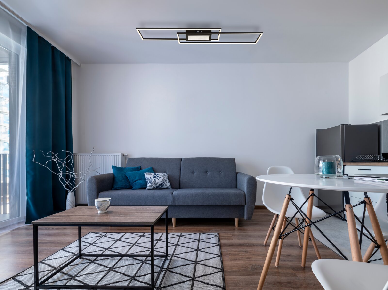 Moderne Deckenleuchte in einem stilvoll eingerichteten Wohnzimmer, aus der Perspektive von unten betrachtet.