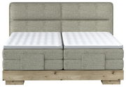 Frontale Ansicht eines Boxspringbetts mit grauem Stoffbezug und Holzfuß.