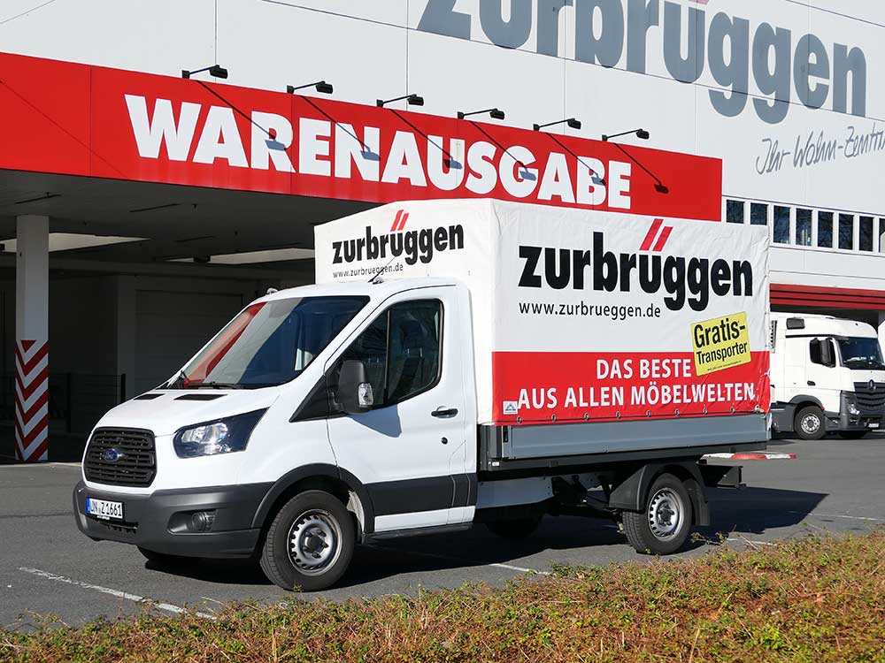 Een witte bestelwagen van Zurbrüggen staat voor de goederenuitgifte.
