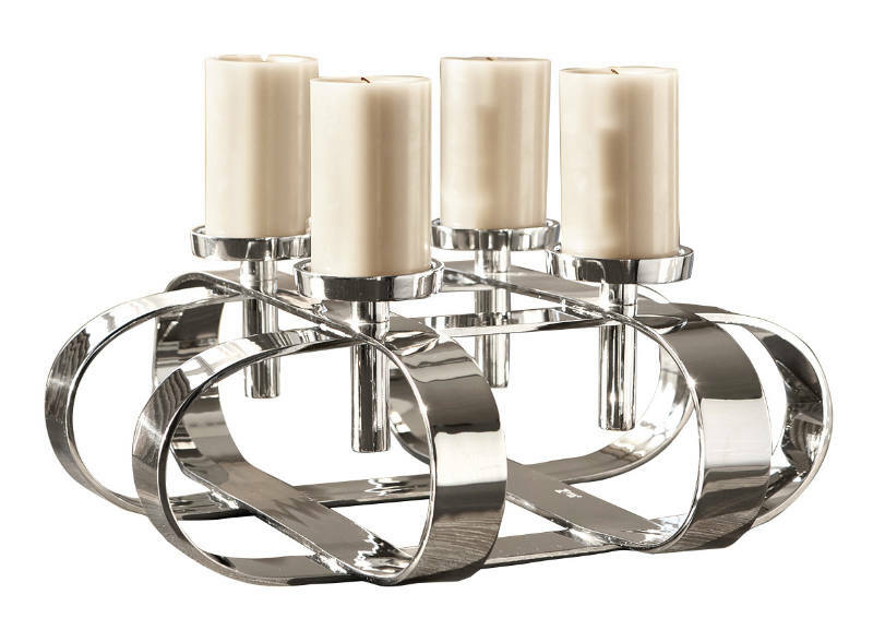 Moderner, vierflammiger Kerzenleuchter aus glänzendem Metall mit cremefarbenen Kerzen, seitliche Perspektive.