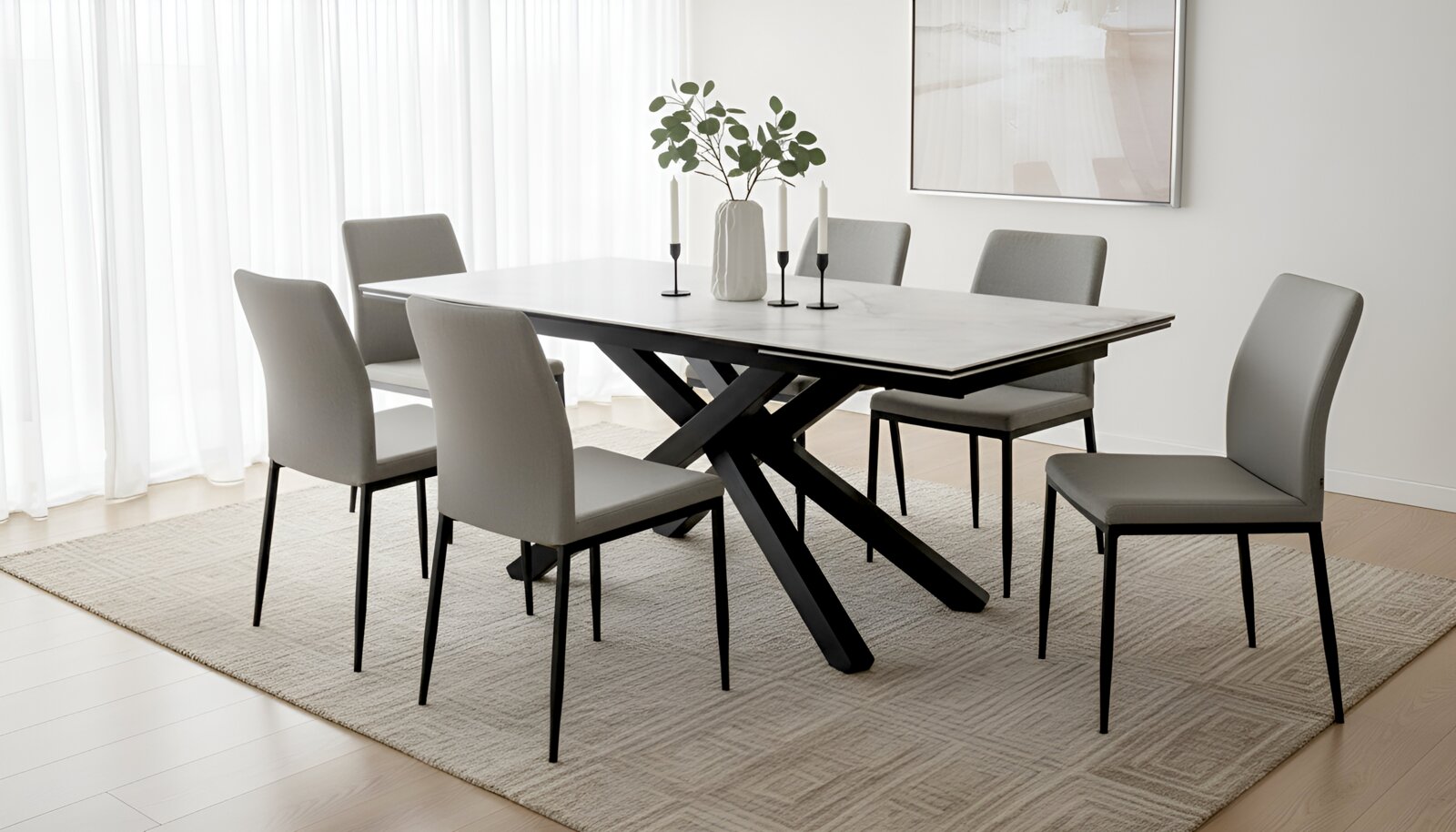 Moderne rechthoekige eettafel met licht marmerlook blad en zwart gekruist onderstel, omringd door zes grijze stoelen, gezien schuin van voren in een lichte eetkamer.