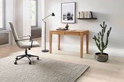 Moderner Schreibtisch aus Holz in einem stilvollen Büro mit einem ergonomischen Bürostuhl, einer Stehlampe und einem Kaktus. Perspektive von der Seite.