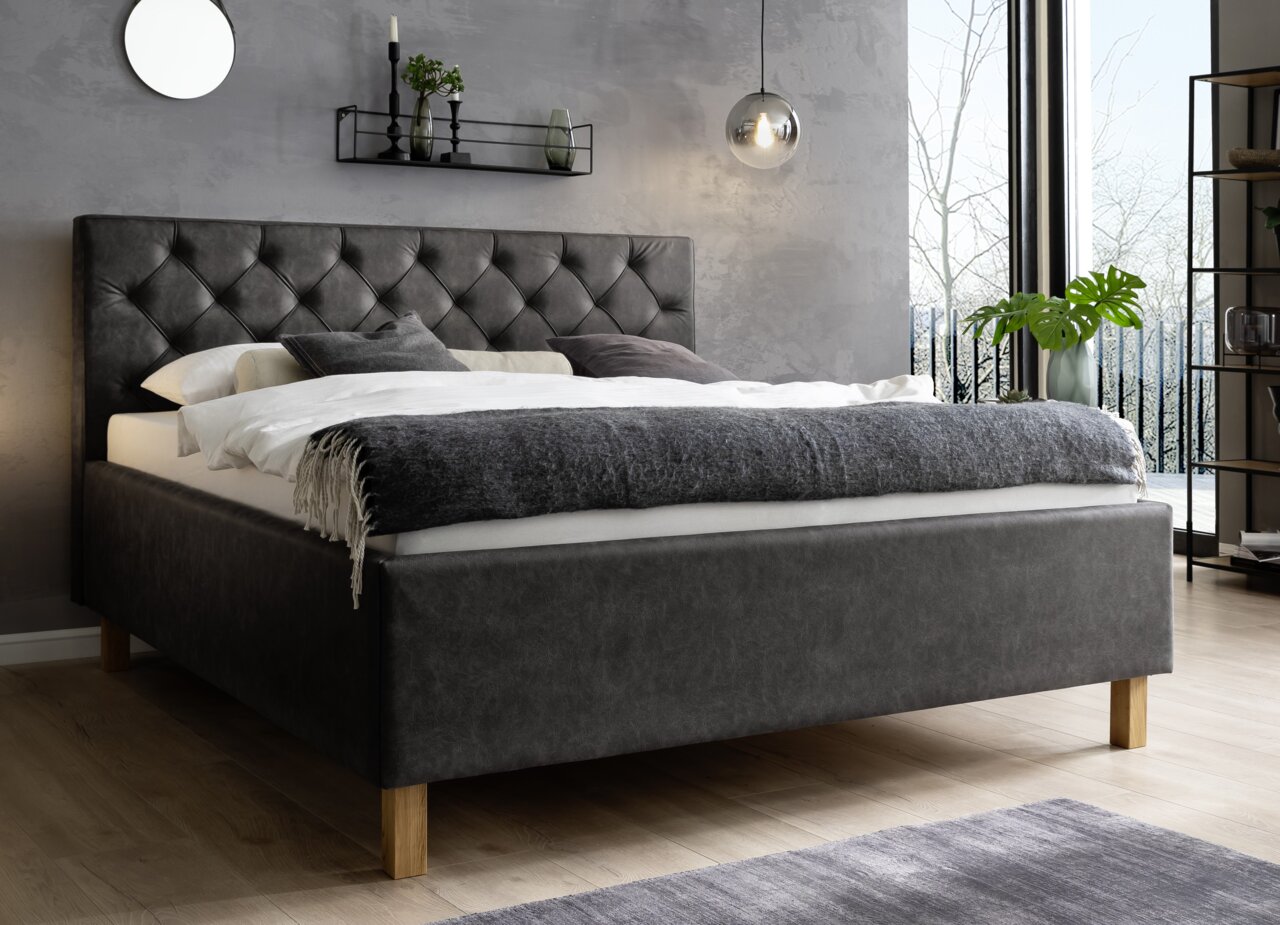 Polsterbett in modernem Schlafzimmer, seitliche Perspektive