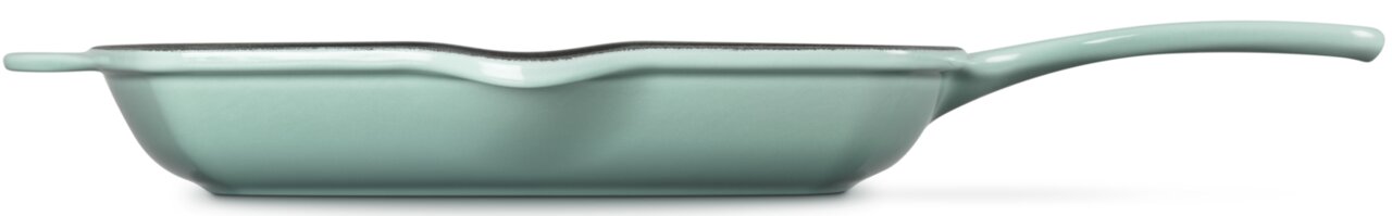 Mintgrüne gusseiserne Bratpfanne mit langem Griff, seitliche Ansicht (Profil) vor weißem Hintergrund