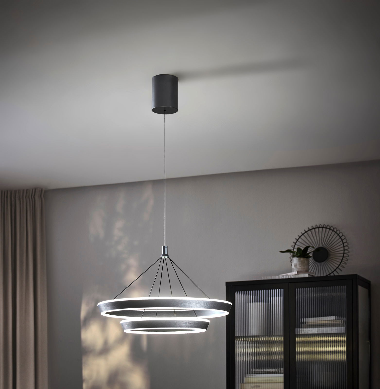 Ambiente LED-Hängeleuchte Moderne LED-Hängeleuchte mit drei ringförmigen Leuchtelementen, von der Decke hängend, seitliche Perspektive