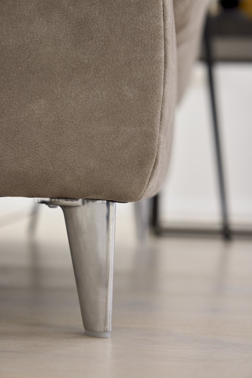 Nahaufnahme eines Sofafußes aus Metall mit beigem Polsterstoff, seitliche Perspektive