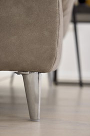 Nahaufnahme eines Sofafußes aus Metall mit beigem Polsterstoff, seitliche Perspektive