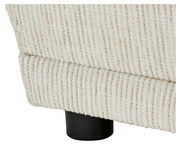 Nahaufnahme der strukturierten, cremefarbenen Polsterung einer Recamiere mit schwarzem Bein, seitliche Perspektive.