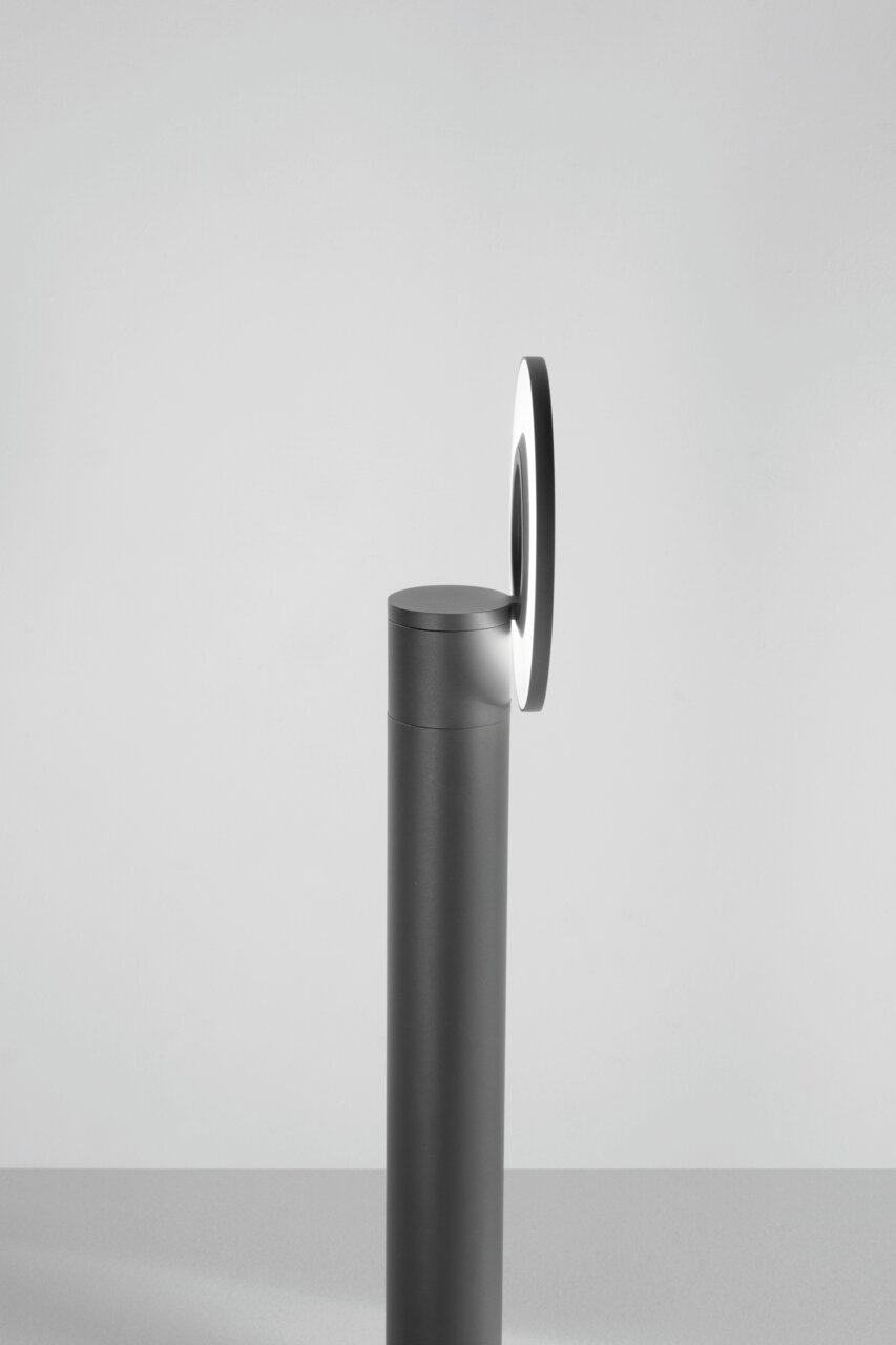 Seitenansicht einer modernen LED-Pollerleuchte mit rundem Leuchtelement auf einem schlanken, zylindrischen Sockel.