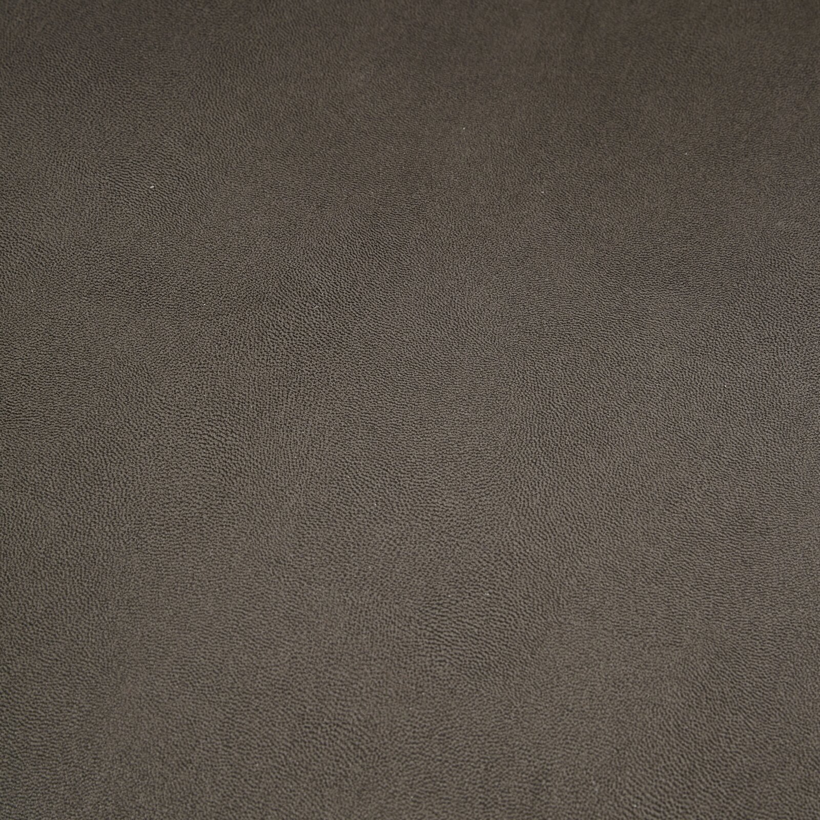 Nahaufnahme einer dunkelgrauen, strukturierten Oberfläche, möglicherweise Stoff oder Leder, von oben betrachtet.