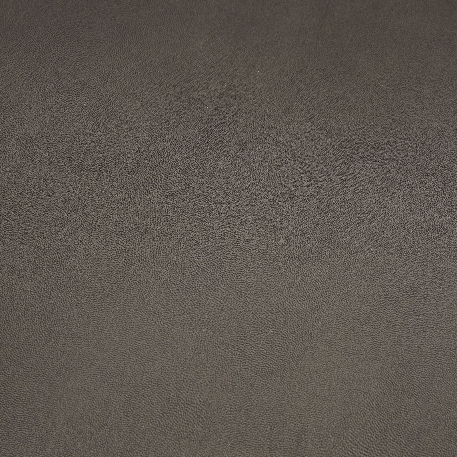 Nahaufnahme einer dunkelgrauen, strukturierten Oberfläche, möglicherweise Stoff oder Leder, von oben betrachtet.