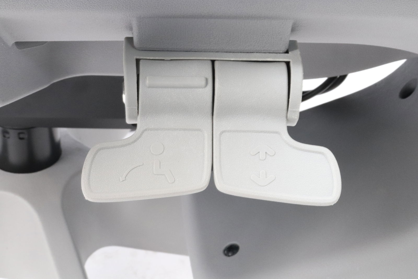 Nahaufnahme der Bedienelemente eines Drehstuhls zur Einstellung der Sitzneigung und Sitzhöhe.