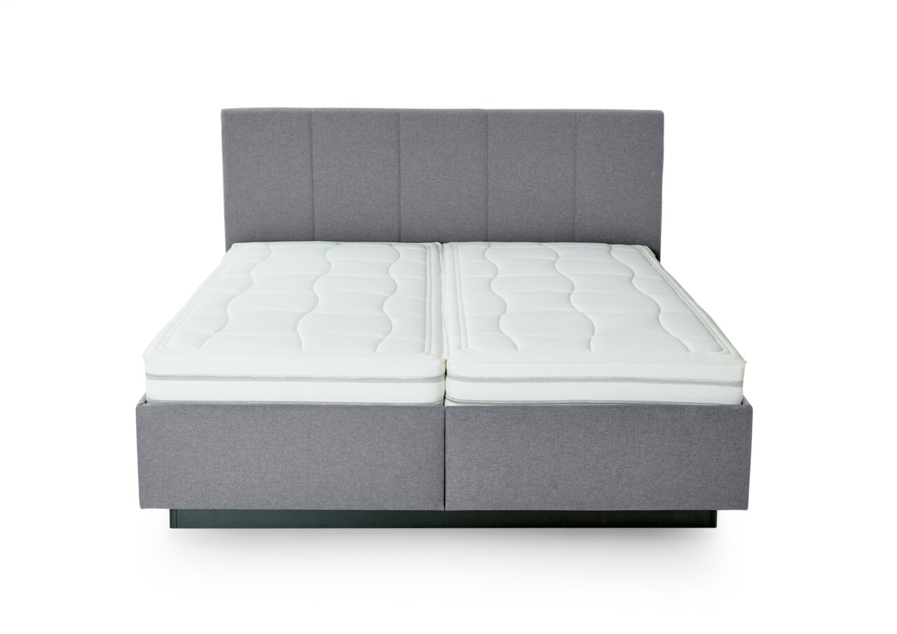 Grijs boxspringbed met twee witte matrassen, vooraanzicht