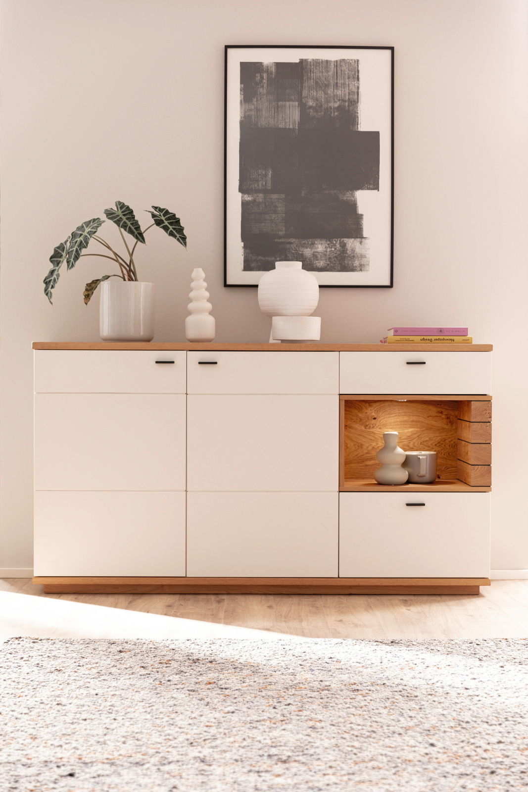 Modernes Sideboard MANITOBA in heller Holzoptik mit dekorativen Vasen und Pflanzen, frontal fotografiert.