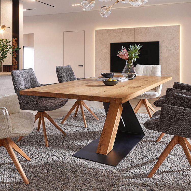 Großer Holzesstisch mit modernen Polsterstühlen in einem hellen, stilvollen Essbereich