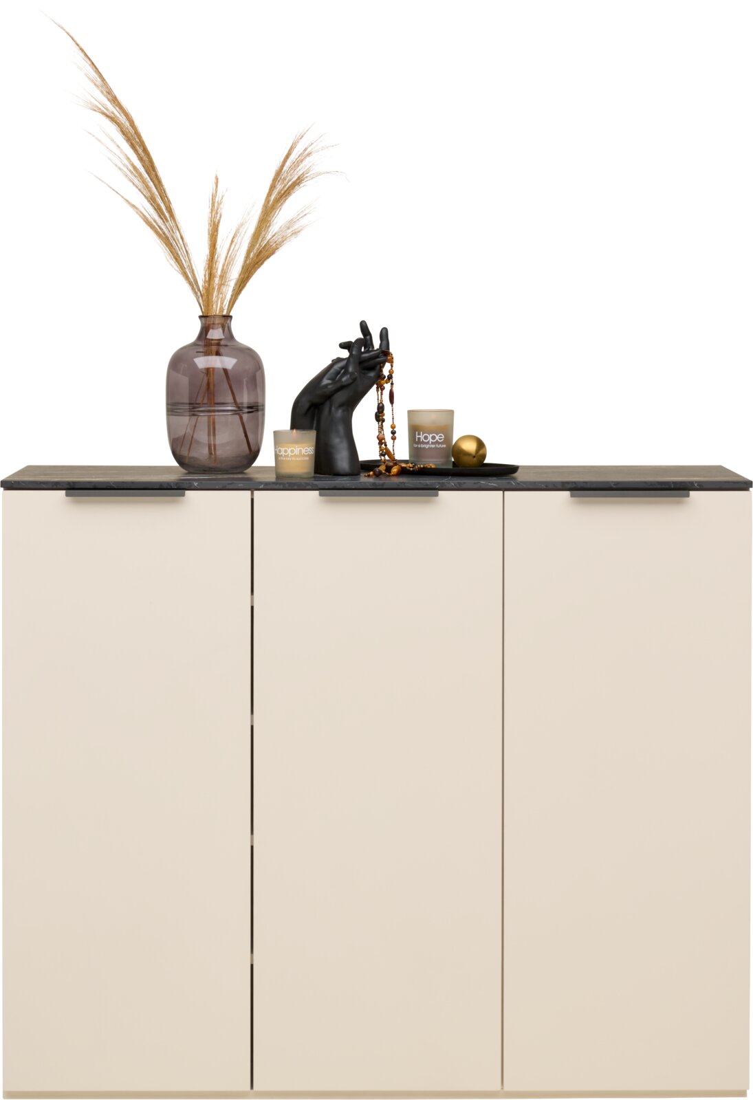 Moderner Schuhschrank mit drei Türen in Cremefarbe, dekoriert mit einer Vase, Kerzen und einer Skulptur auf der Oberseite, Frontalansicht.