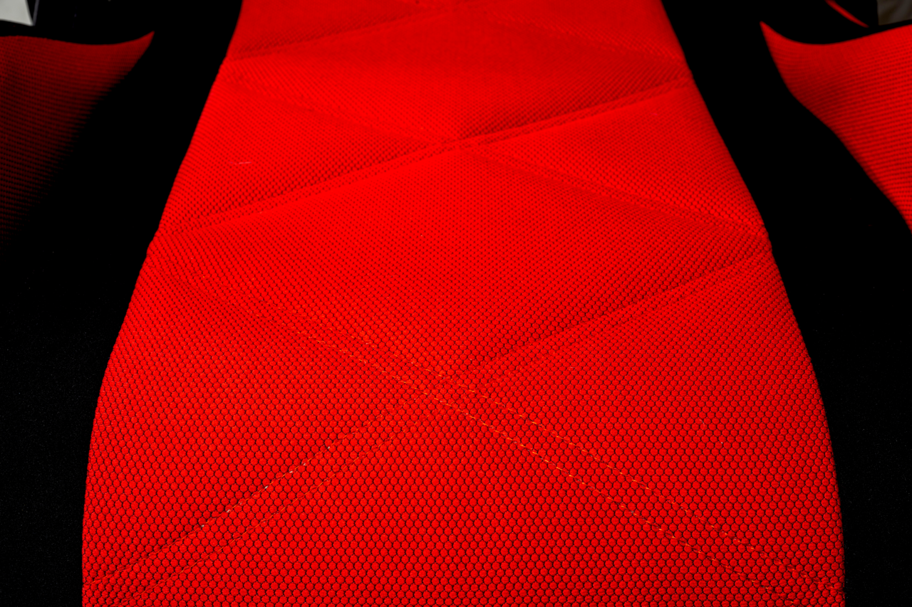 Nahaufnahme eines roten Gaming-Stuhls mit schwarzem Rand, aus der Vogelperspektive fotografiert.