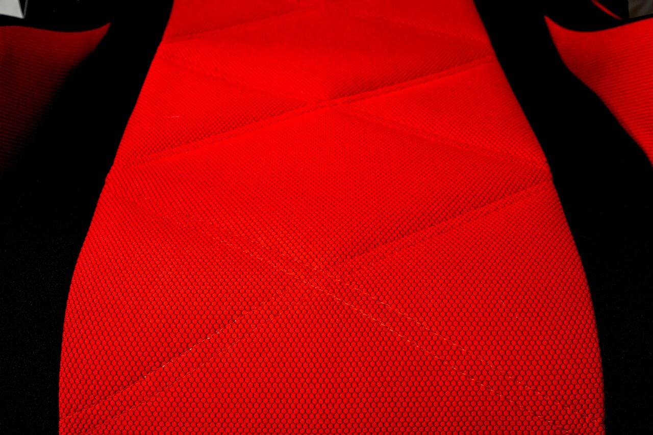 Nahaufnahme eines roten Gaming-Stuhls mit schwarzem Rand, aus der Vogelperspektive fotografiert.