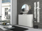 Modernes weißes Sideboard im Flur vor grauer Steinwand, mit rundem Spiegel und Deko auf der Ablage; Ansicht schräg von vorn.