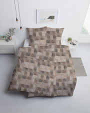 Beddengoedset met geometrisch patroon in beige- en bruintinten, van bovenaf gefotografeerd in een moderne slaapkamer.