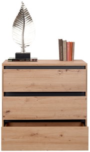 Kommode aus Holz mit drei Schubladen, eine davon leicht geöffnet, dekoriert mit einer silbernen Blattskulptur und Büchern, Frontalansicht.