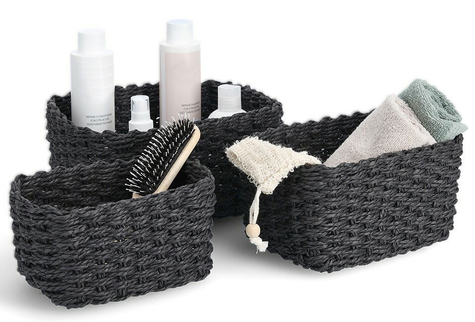 Dreiteiliges Aufbewahrungskorb-Set in Schwarz, gefüllt mit Pflegeprodukten und Handtüchern, aus einer leicht erhöhten Perspektive fotografiert.