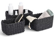 Dreiteiliges Aufbewahrungskorb-Set in Schwarz, gefüllt mit Pflegeprodukten und Handtüchern, aus einer leicht erhöhten Perspektive fotografiert.