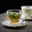 Glas-Tasse mit frischem Minztee auf Untertasse, seitliche Perspektive