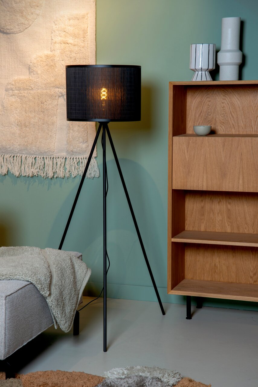 Moderne Stehlampe mit schwarzem Schirm und dreibeinigem Stativ, seitliche Perspektive