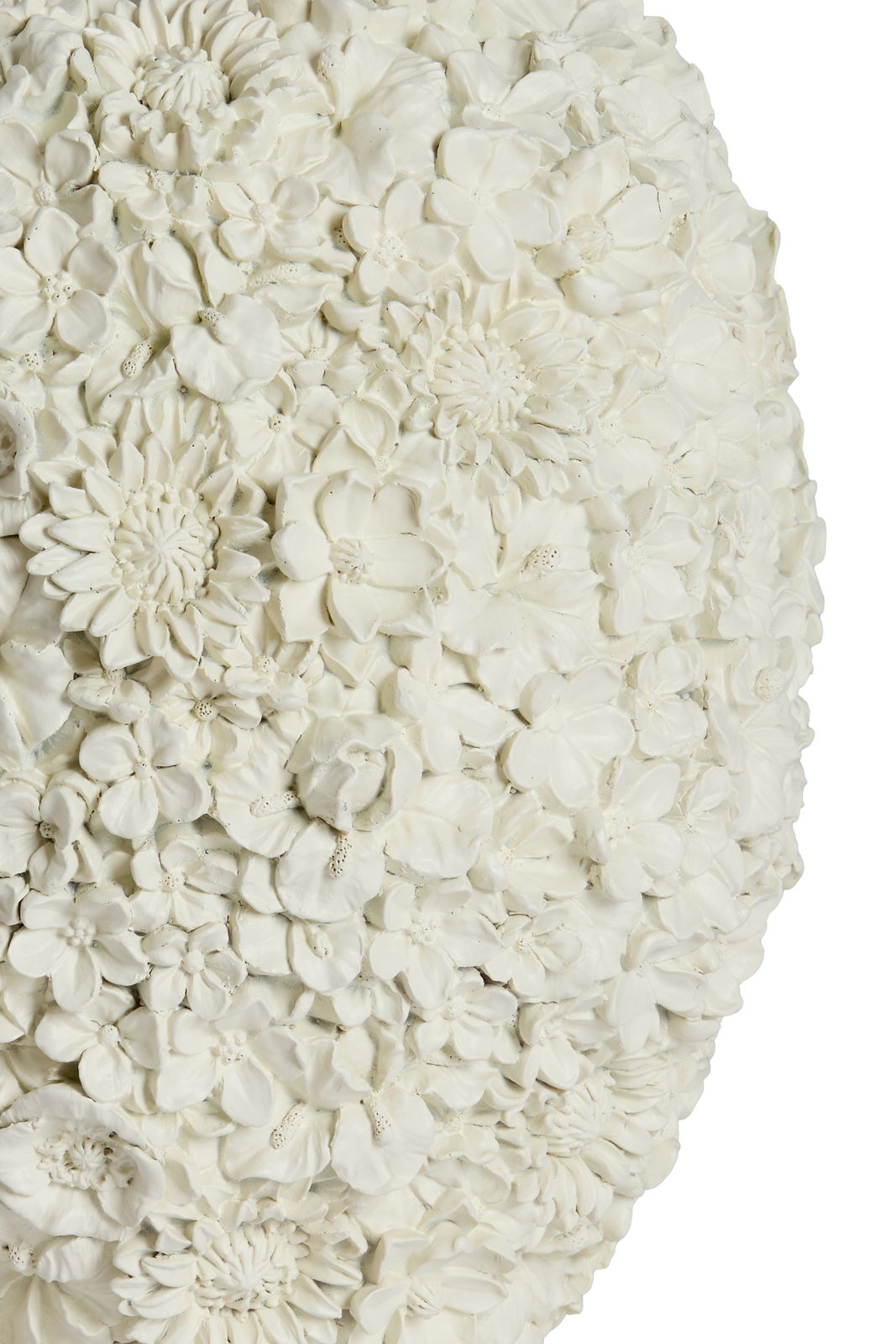 Nahaufnahme einer Vase mit detailliertem Blumenrelief in Weiß, seitliche Perspektive.