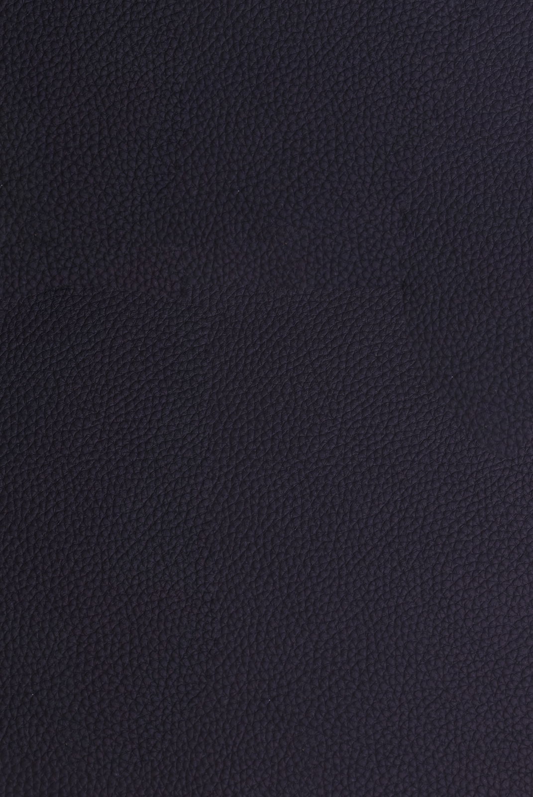 Nahaufnahme einer dunkelblauen, strukturierten Lederoberfläche, von oben betrachtet.