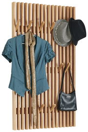 Garderobenpaneel aus Holz mit mehreren Haken, darauf hängen ein blauer Blazer, ein goldener Schal, zwei Hüte und eine schwarze Tasche. Frontalansicht.