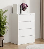 Weiße, moderne Kommode mit vier Schubladen in einem hellen Raum, auf der Oberseite Bücher und eine Vase mit violetten Blumen; Ansicht leicht schräg von vorn.