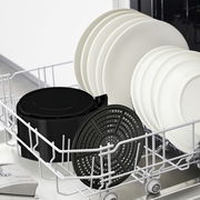 Blick auf die spülmaschinenfesten Teile der Heißluftfritteuse EasyFry Ultra im Geschirrspüler, neben weißen Tellern.