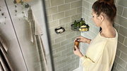Eck-Duschablage in Schwarz mit Pflegeprodukten, seitliche Perspektive