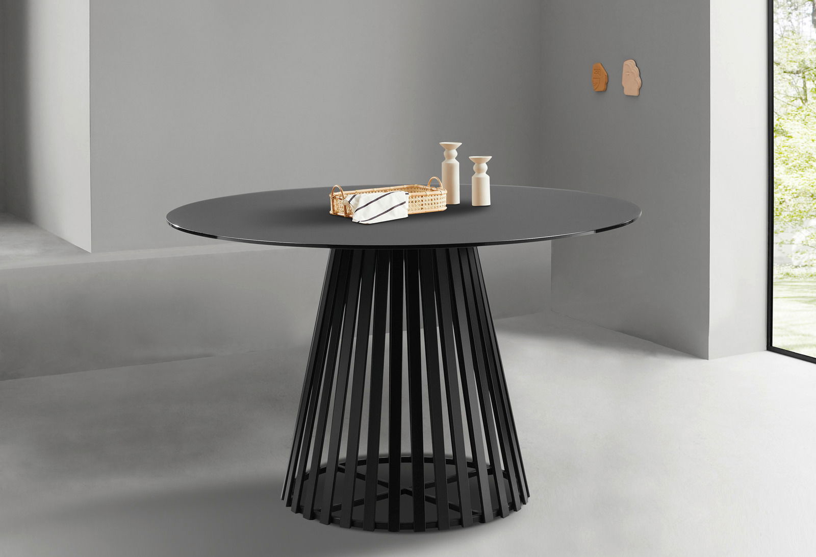 Moderner runder Esstisch mit schwarzer Tischplatte und stilvollem, konischen Metallgestell, seitliche Perspektive